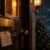 Alte Holztür bei Nacht mit leerem Namensschild und Zettel, dahinter tausend kleine Lichter im Regen